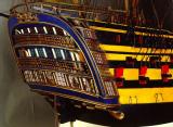 Popa del modelo del navío Santa Ana visto desde su aleta de estribor. La primera y segunda baterías con tapaderas en las portas y el casco pintado a franjas negras y amarillas, como se reglamentó en la Armada a partir de 1810.